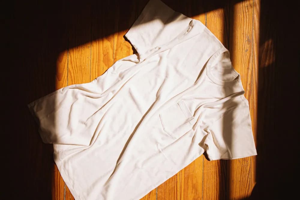 Foto original de una camiseta blanca extendida sobre un piso de madera
